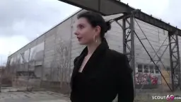 Dark-haired woman in black coat on urban square