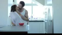 Secretary in white bodysuit, man kissing her in minimal kitchen
