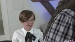 Young woman with glasses kneels in front of older cock