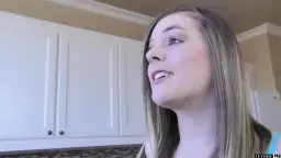 Woman sits on kitchen counter, legs spread