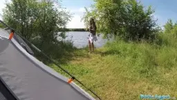 Morena pescando en la orilla del lago, tienda al fondo