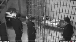 Woman in orange tank top kneeling on floor in front of cell bars