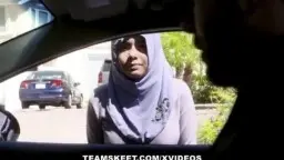 Man in car, surprised with raised eyebrows, green trees in background
