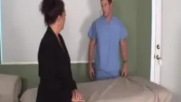 Mature woman sitting sideways on treatment table, man standing beside her